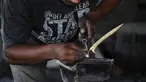 Seorang pandai besi membuat keris tradisional yang dikenal sebagai 'rencong' di sebuah bengkel di Sibreh, provinsi Aceh (5/10/2021). Rencong merupakan senjata khas Suku Aceh. (AFP/Chaideer Mahyuddin)