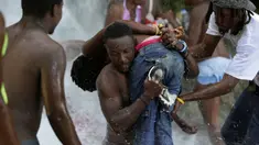 Sejumlah  peziarah mandi di bawah air terjun di Saut d' Eau, Haiti, (16/7). Ini merupakan ritual tahunan untuk menyembuhkan penyakit dan mensucikan diri. (REUTERS/Andres Martinez Casares)