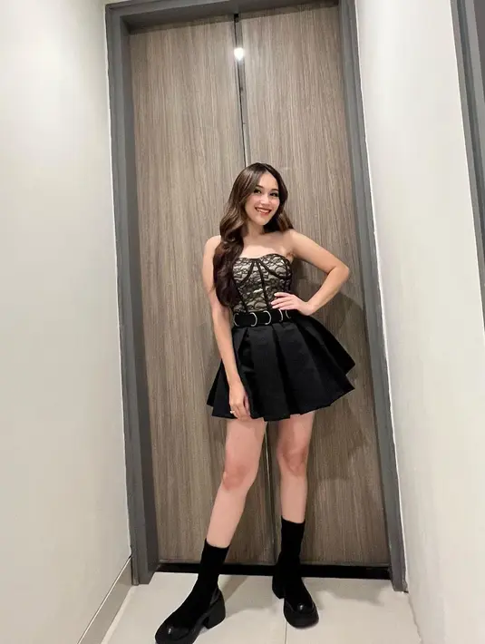 Penampilan ala black swan lainnya dari Ayu Ting Ting saat ia mengenakan mini dress warna hitam dari @ametdistri. Dress tersebut hadir dengan detail corset berenda dengan rok rample di bawahnya. [@ayutingting92]