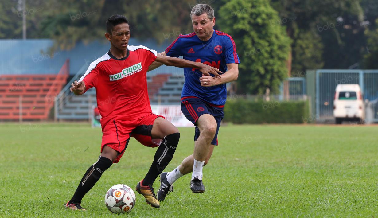 Denis Irwin (kanan) saat berebut bola dengan pemain Dream team A pada acara United Way Coaching Clinic You C 1000 di Stadion Soemantri Brojonegoro, Jakarta, Sabtu (7/5/2016). (Bola.com/Nicklas Hanoatubun)