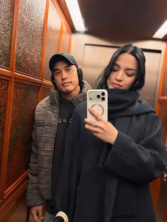 Lewatkan tahun baru, pasutri ini kenakan busana musim dingin bernuansa gelap. Nia Ramadhani kenakan long coat dan syal, sedangkan Ardi Bakrie pilih lapisi hoodie dan jaket tebal [@ramadhaniabakrie]