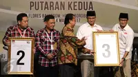 Pasangan cagub dan cawagub Anies Baswedan dan Sandiaga Uno menerima plakat yang diberikan oleh ketua KPU DKI Jakarta, Sumarno saat rapat pleno terbuka di Jakarta, Sabtu (4/3). (Liputan6.com/Angga Yuniar)