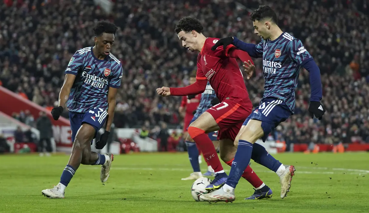 Gelandang Liverpool Curtis Jones (tengah) berebut bola dengan penyerang Arsenal Gabriel Martinelli pada leg pertama semifinal Piala Liga Inggris di Stadion Anfield, Jumat (14/1/2022) dinihari WIB. Arsenal dipkasa bermain imbang tanpa gol oleh Liverpool. (AP Photo/Jon Super)