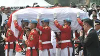 Paspampres mengusung peti jenazah almarhum Presiden ke-3 RI BJ Habibie menuju liang lahat saat tiba di TMP Kalibata, Jakarta, Kamis (12/9/2019). Dimakamkan secara militer, jenazah BJ Habibie diiringi derap marching band dan lantunan kalimat tahlil dari para pelayat. (merdeka.com/Iqbal Nugroho)