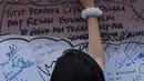 Pengunjung menuliskan dukungan buat Polri pasca kerusuhan di Rutan cabang Salemba Mako Brimob saat acara Car Free Day di Kawasan Bundaran Hotel Indonesia, Jakarta, Minggu (13/5). (Liputan6.com/Helmi Fithriansyah)