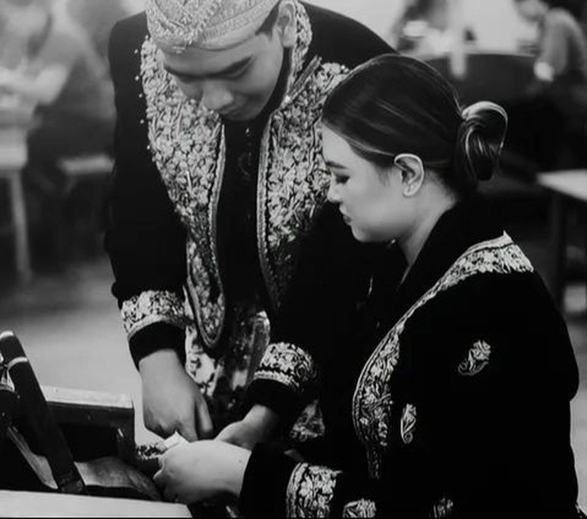 Tampak calon pengantin pria berpose seolah mengajari pengantin wanita cara melinting rokok. Hasilnya&nbsp; terlihat sangat estetik.