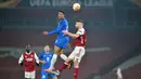 Penyerang Molde, Mathis Bolly (tengah) melompat untuk menyundul bola di depan bek Arsenal Shkodran Mustafi (kanan) selama pertandingan grup B Liga Europa di Emirates Stadium di London (5/11/2020). Arsenal menang telak atas Molde 4-1. (AFP/Glyn Kirk)