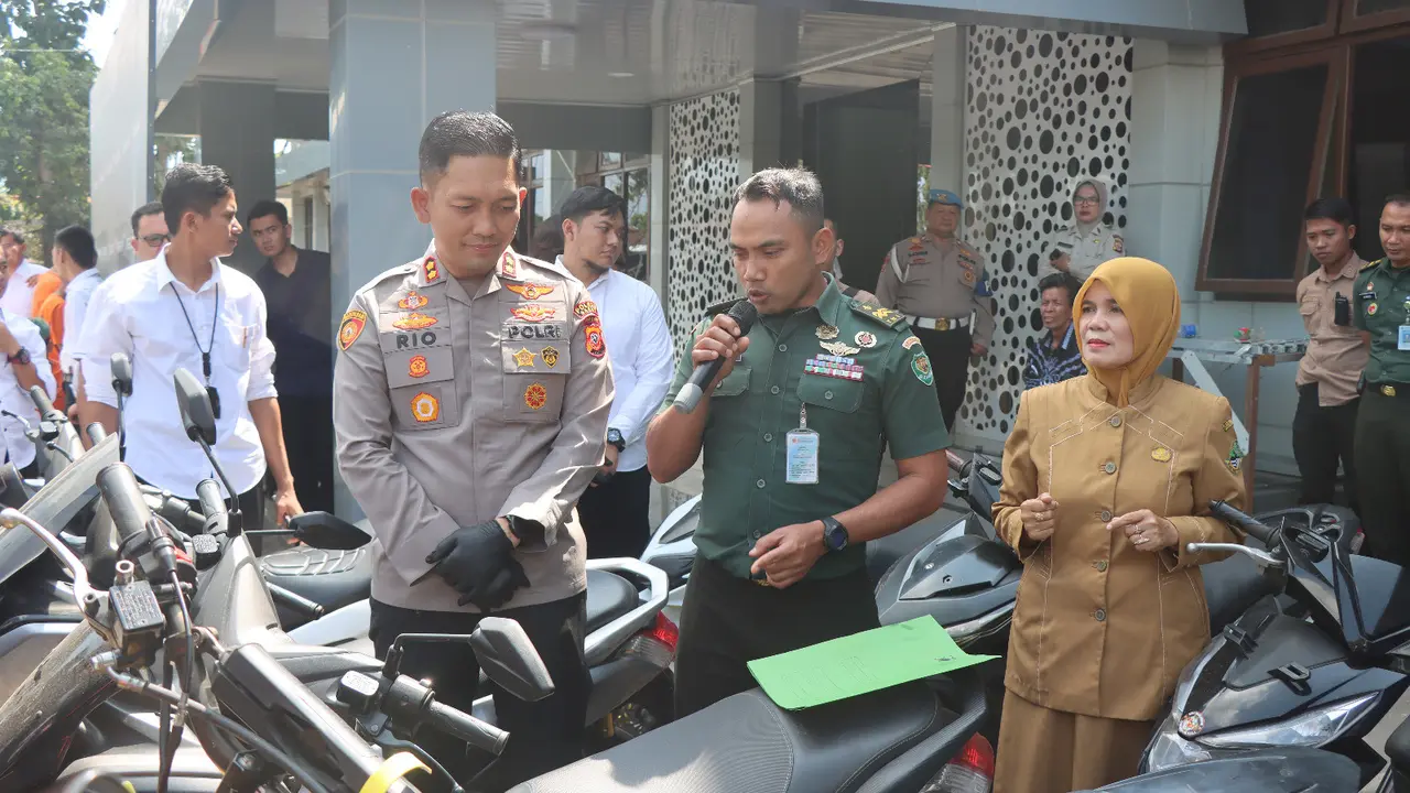 Kapolres Garut AKBP Rio Wahyu Anggoro, mendampingi seorang petugas militer dalam rilis kasus pencurian kendaraan bermotor di Mapolres Garut, Senin (12/6/2023). (Liputan6.com/Jayadi Supriadin)