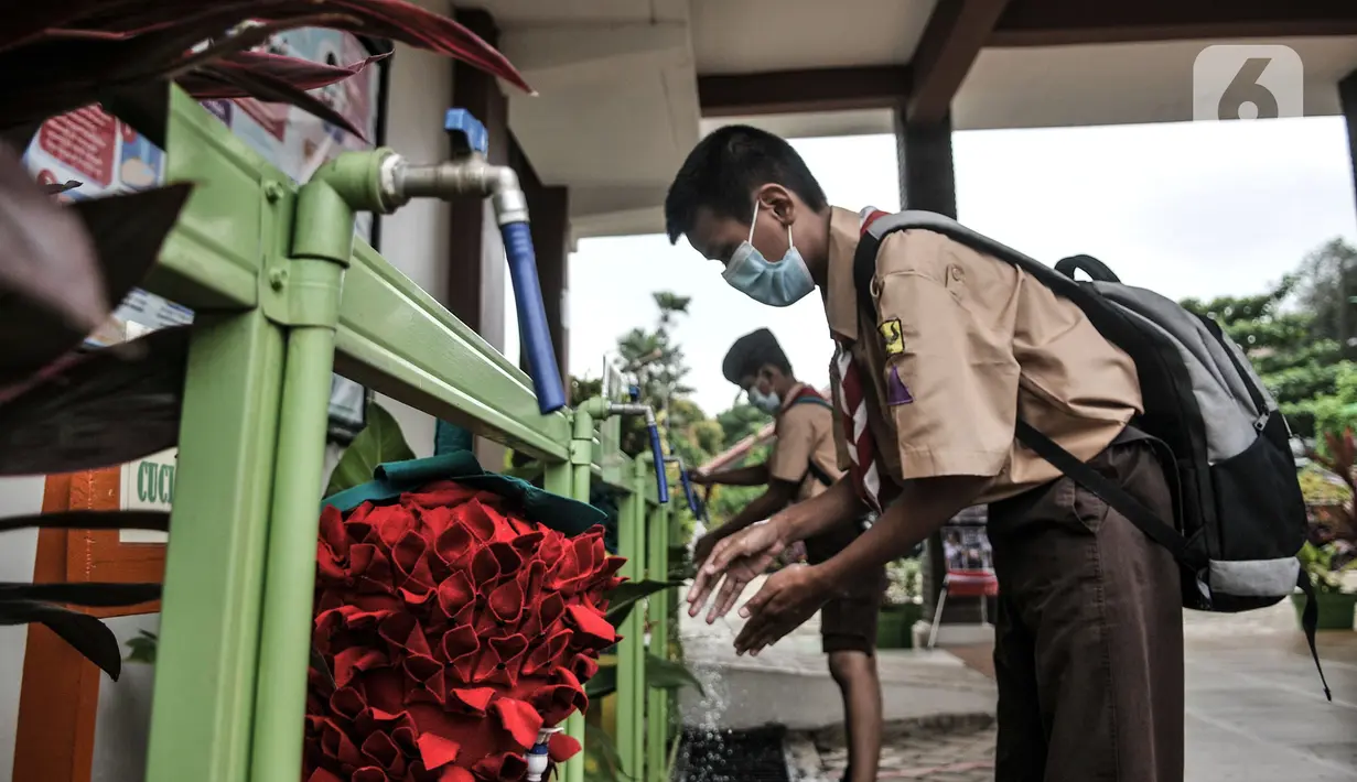 Siswa mencuci tangan saat hari pertama uji coba pembelajaran tatap muka di SDN Pulogadung 07, Jakarta, Rabu (7/4/2021). Pembelajaran tatap muka dilakukan dengan pembatasan 50 persen dari kapasitas kelas. (merdeka.com/Iqbal S. Nugroho)