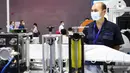 Seorang staf berdiri di samping mesin pembuat masker KN95 dalam Pameran Pasokan Pelindung Medis Internasional Guangzhou di Poly World Trade Center Expo, Guangzhou, Guangdong, China, Rabu (10/6/2020). Pameran tersebut diikuti sekitar 600 peserta. (Xinhua/Deng Hua)