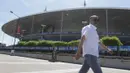 Seorang warga melintas di depan Stadion Stade de France, Paris, Prancis, Sabtu (9/7/2016). Stadion ini akan menggelar laga final Piala Eropa 2016 antara Prancis melawan Portugal. (Bola.com/Vitalis Yogi Trisna)