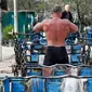 Seorang pria bersiap untuk berlatih mengangkat beban di outdoor gym atau pusat kebugaran terbuka di tepi Sungai Dnipro, Kiev, Ukraina, Kamis (18/4). Pusat kebugaran ini dibangun karena minimnya fasilitas olahraga yang terjangkau oleh warga. (AP Photo/Efrem Lukatsky)