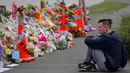 Seorang pelajar termenung saat menggelar mengenang korban penembakan di luar Masjid Al Noor, Christchurch, Selandia Baru, Senin (18/3). Penembakan tersebut merupakan serangan terburuk dalam sejarah Selandia Baru modern. (AP Photo/Vincent Yu)