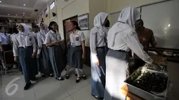 Sejumlah siswa SMA yang  lolos seleksi Paskibraka  mengantri makanan sebelum mengikuti pendalaman materi di Gedung PP-PON Menpora Cibubur, Jakarta, Rabu (27/7). (Liputan6.com/Yoppy Renato)