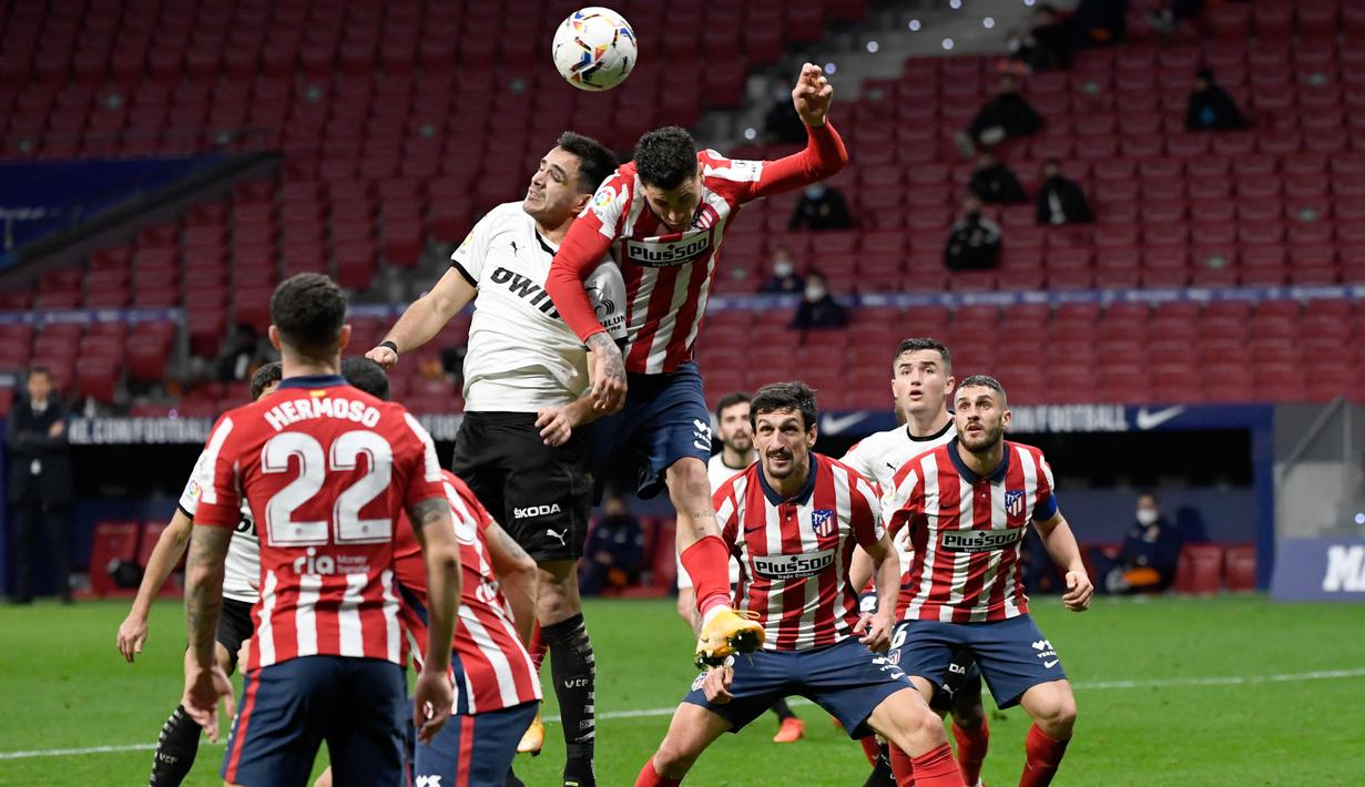 Pemain Atletico Madrid, Jose Gimenez, duel udara dengan pemain Valencia, Maxi Gomez, pada laga Liga Spanyol di Stadion Wanda Metropolitano, Minggu (24/1/2021). Atletico Madrid menang dengan skor 3-1. (AFP/Pierre Philippe Marcou)