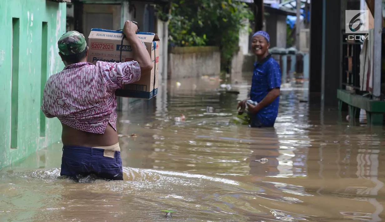 Warga melintasi banjir di kampung Arus Cawang, Jakarta Timur, Jumat (26/4). Ketinggan banjir kurang lebih satu meter terjadi akibat luapan kali Ciliwung dan intensitas curah hujan di kawasan Bogor Jawa Barat sangat tinggi sehingga aktivitas warga terhambat. (merdeka.com/Imam Buhori)