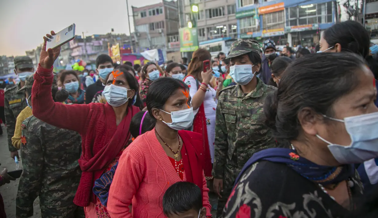 Umat Hindu Nepal berkumpul untuk berdoa kepada matahari terbenam di tepi Sungai Bagmati selama festival Chhath Puja di Kathmandu, Nepal, Rabu (10/11/2021). Ritual dilakukan untuk berterima kasih kepada Dewa Matahari karena telah menopang kehidupan di bumi. (AP Photo/Niranjan Shrestha)