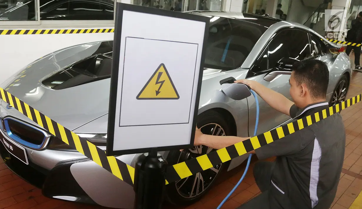 Seorang mekanik tengah mengisi daya BMW i8 saat pembukaan diler baru BMW di Tebet, Jakarta, Selasa (12/12). Diler ini dikhususkan untuk mobil listrik ramah lingkungan BMW i8. (Liputan6.com/Pool/BMW)