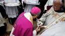 Administrator Apostolik Patriarkat Latin Yerusalem, Uskup Agung Pierbattista Pizzaballa mencium sebuah salib perak selama misa di Manger Square di luar Gereja Nativity di Kota Betlehem, Palestina, Minggu (24/12). (AFP/Musa Al Shaer)