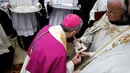 Administrator Apostolik Patriarkat Latin Yerusalem, Uskup Agung Pierbattista Pizzaballa mencium sebuah salib perak selama misa di Manger Square di luar Gereja Nativity di Kota Betlehem, Palestina, Minggu (24/12). (AFP/Musa Al Shaer)