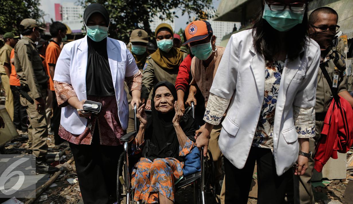 Petugas mengevakuasi warga saat penggusuran di Rawasari Selatan, Jakarta, Kamis (23/7/2015). Tim medis disiagakan dalam upaya penggusuran bangunan di Rawasari Selatan, Jakarta. (Liputan6.com/Faizal Fanani)
