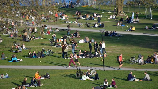 Orang-orang menikmati cuaca hangat di Stockholm, Rabu (22/4/2020). Swedia belum memberlakukan lockdown, seperti mayoritas negara Eropa lainnya, namum pemerintah memberikan tanggung jawab besar kepada penduduknya untuk membantu mengurangi penyebaran virus corona. (Anders WIKLUND/TT NEWS AGENCY/AFP)