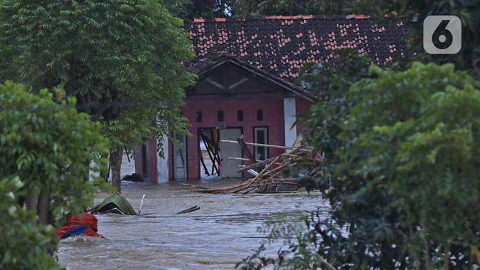Suasana banjir akibat tanggul jebol di Desa Sumberurip Pebayuran, Kabupaten Bekasi, Jawa Barat, Senin (22/2/2021). Banjir akibat luapan sungai Citarum mengakibatkan 5 Desa terisolir selama tiga hari akibat tanggul sungai Citarum jebol. (Liputan6.com/Herman Zakharia)