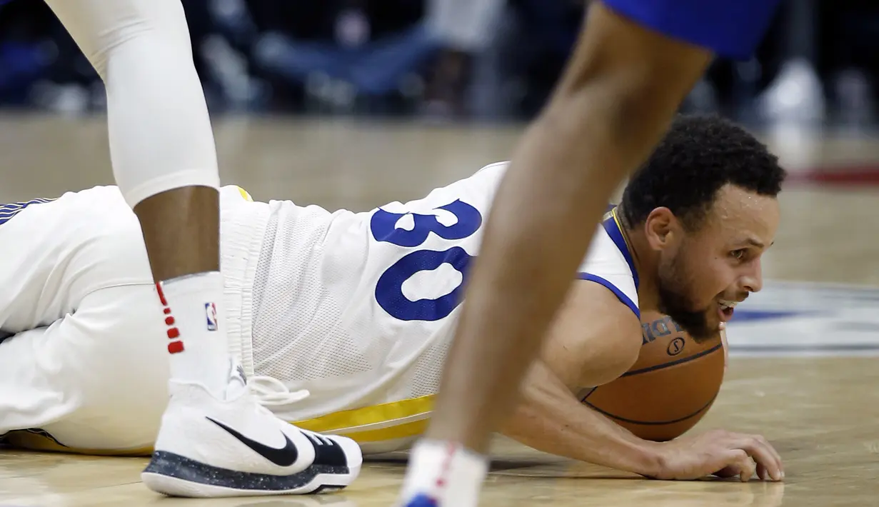 Pemain Golden State Warriors, Stephen Curry (30) jatuh saat berebut bola dengan pemain Los Angeles Clippers pada laga NBA basketball game di Staples Center, Los Angeles, (6/1/2018). Warriors 121-105. (AP/Alex Gallardo)