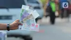 Penjual jasa penukaran uang pecahan menunggu konsumen di Jalan Otista Raya di Karawaci, Kota Tangerang, Senin (10/5/2021). Penjual jasa penukaran uang baru musiman tersebut mulai bermunculan menjelang lebaran yang dikenakan tarif jasa sebesar 10 persen. (Liputan6.com/Angga Yuniar)
