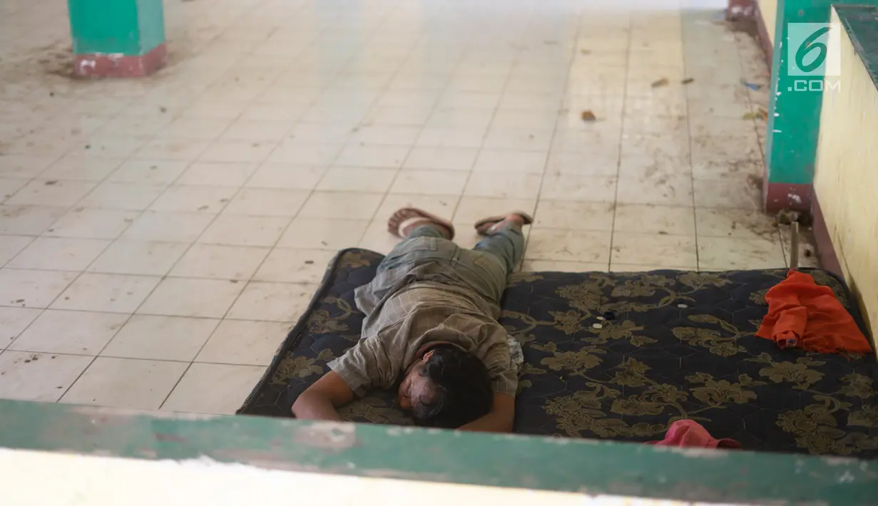 Seorang pria tidur di bekas rumah makan yang lama ditinggalkan di Jalur Pantura, Jawa Barat, Sabtu (8/6/2019). Banyak rumah makan yang bangkrut sejak pemudik lebih memilih melalui Jalan Tol Cikopo-Palimanan (Cipali) yang merupakan bagian dari Tol Trans Jawa. (Liputan6.com/Immanuel Antonius)