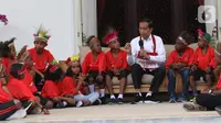 Presiden Joko Widodo atau Jokowi bercengkerama dengan perwakilan anak-anak sekolah dasar dari Papua di Istana Merdeka, Jakarta, Jumat (11/10/2019). Perwakilan anak-anak sekolah dasar dari Papua tersebut akan diajak jalan-jalan keliling Jakarta didampingi oleh staf Istana. (Liputan6.com/Angga Yuniar)