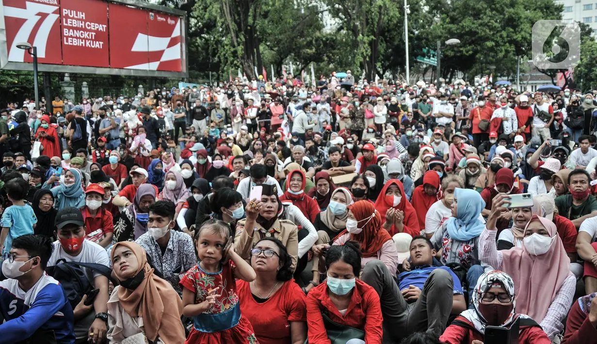 Warga melihat Upacara HUT ke-77 Republik Indonesia yang disaksikan dari Taman Aspirasi Monumen Nasional (Monas), Rabu (17/8/2022). Setelah sempat ditiadakan selama 2 tahun akibat pandemi Covid-19, Upacara Peringatan Kemerdekaan Republik Indonesia disambut antusias warga dari berbagai daerah yang berdatangan untuk mengikuti meski hanya dari luar Istana Negara. (merdeka.com/Iqbal S Nugroho)
