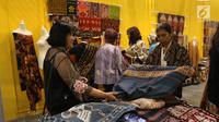 Pengunjung melihat kain selama pameran Karya Kreatif Indonesia (KKI) di Jakarta, Jumat (12/7/2019). Pameran KKI 2019 ini berlangsung selama 3 hari menampilkan produk-produk UMKM RI mulai dari kain, pakaian, tas, hingga berbagai kuliner seperti kopi buatan anak negeri. (Liputan6.com/Angga Yuniar)