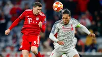 Duel udara penyerang Bayern Munchen, Robert Lewandowski dan bek Liverpool, Virgil Van Dijk pada pertandingan leg kedua babak 16 besar Liga Champions di Allianz Arena, Rabu (13/3). Liverpool menundukkan tuan rumah Bayern Munchen 3-1. (AP/Matthias Schrader)