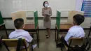 Seorang guru dengan pelindung wajah mengajar siswanya di sebuah kelas di Samkhok School di Pathum Thani, Bangkok, Rabu (1/7/2020). Thailand telah memulai fase kelima relaksasi pembatasan covid-19 yang memungkinkan kembali dibukanya sekolah-sekolah setelah ditutup sejak Maret lalu. (AP/Sakchai Lalit)