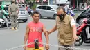 Petugas membawa warga yang tidak mengenakan masker saat razia pelanggar PSBB di Jalan Raya Cinere, Depok, Jawa Barat, Senin (24/8/2020). Razia ditujukan bagi warga yang tidak mengenakan masker untuk menekan penyebaran COVID-19. (merdeka.com/Arie Basuki)