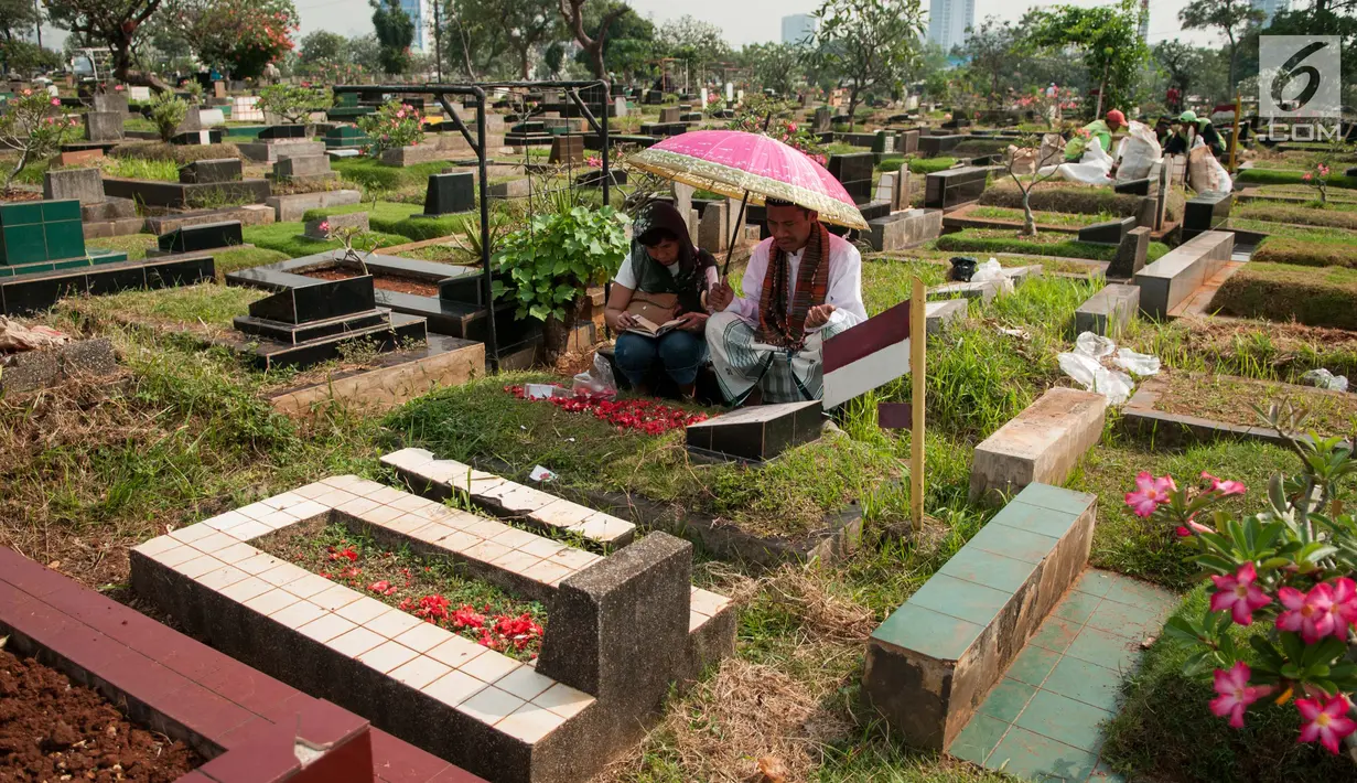 Warga berdoa saat berziarah ke makam keluarganya di TPU Karet Bivak, Jakarta, Sabtu (19/5). Tradisi ziarah dilakukan umat Muslim untuk mendoakan arwah keluarga menjelang datangnya bulan suci Ramadhan. (Liputan6.com/Gempur M Surya)
