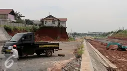 Pekerja mengganti ban di samping Musala yang masih berdiri di lokasi pembangunan proyek Tol Cinere-Jagorawi (Cijago) seksi II di Depok, Jawa Barat, Selasa (1/11). (Liputan6.com/Johan Tallo)