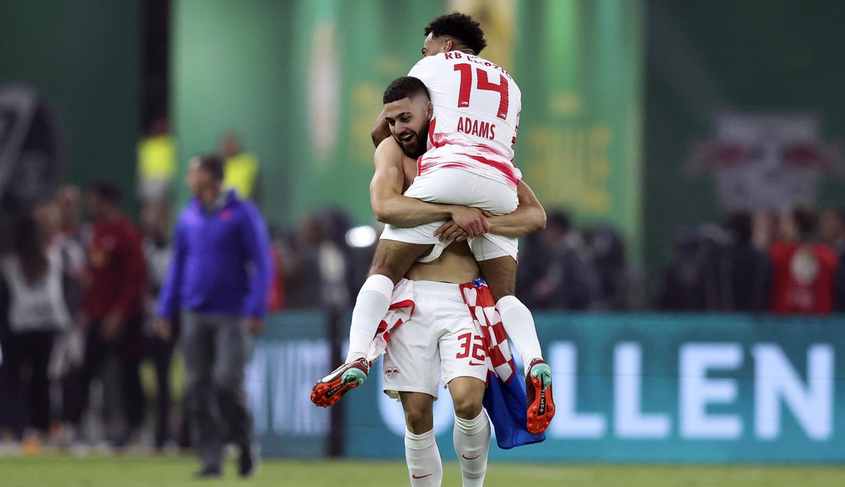 Pemain Leipzig, Josko Gvardiol (kiri) dan Tyler Adams merayakan kemenangan timnya usai mengalahkan SC Freiburg pada partai final DFB Pokal atau Piala Liga Jerman yang berlangsung di Stadion Olimpiade di Berlin, Jerman, Sabtu, 21 Mei 2022 waktu setempat. Die Bullen berhasil menang lewat babak adu penalti dengan skor 4-2 usai laga berjalan imbang 1-1. (AP/Michael Sohn)