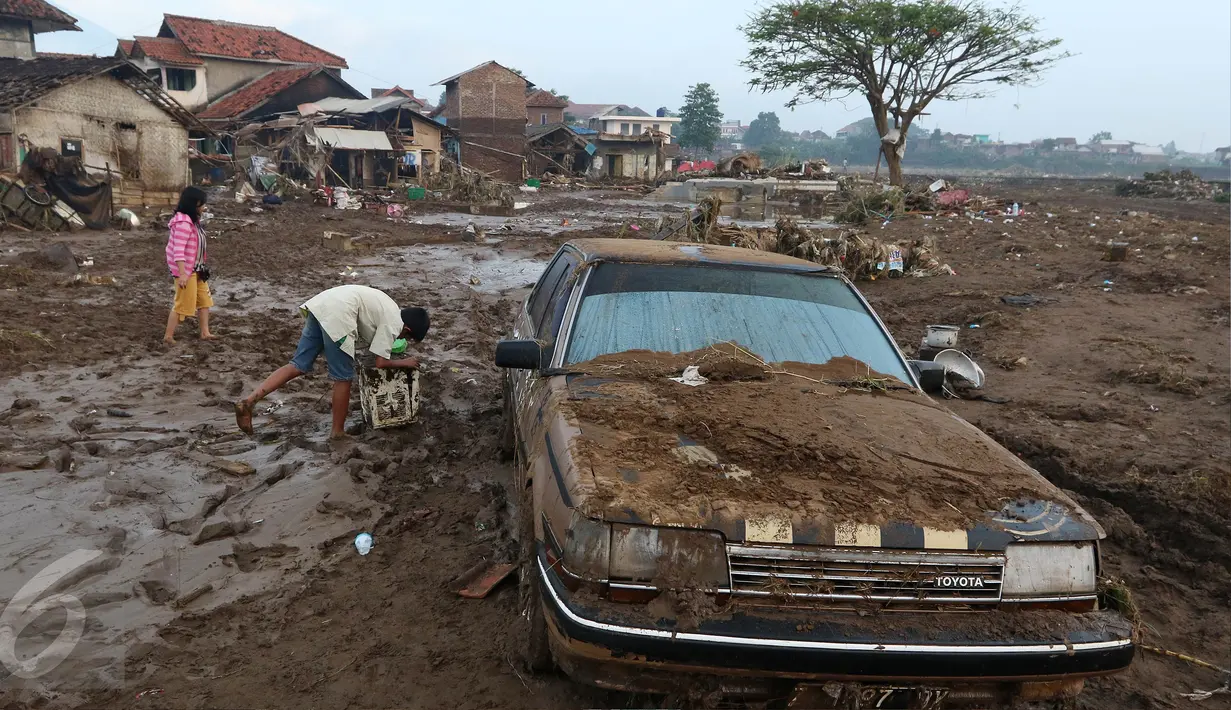 Sebuah mobil tertutup lumpur akibat banjir bandang di Kampung Cimacan, Kecamatan Tarogong, Kabupaten Garut, Kamis (22/9). Berdasarkan data sementara Basarnas Jabar 57 rumah hanyut dan 633 rumah terendam serta 59 orang luka-luka. (Liputan6.com/Johan Tallo)