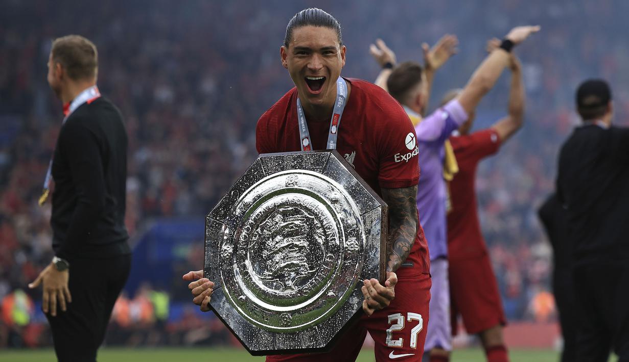 Pemain Liverpool, Darwin Nunez merayakan kemenangan timnya sambil membawa trofi Community Shield 2022/2023 usai mengalahkan Manchester City 3-1 di King Power Stadium, Sabtu (30/07/2022). (AP/Leila Coker)