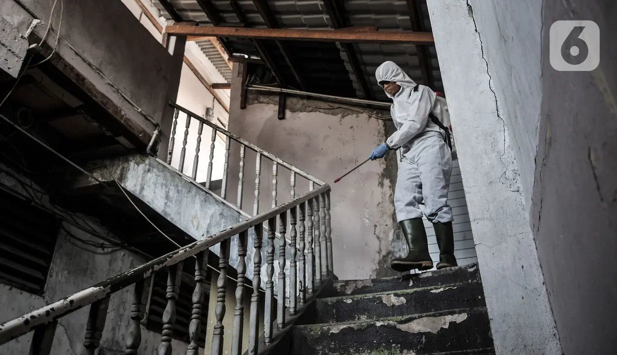 Petugas Palang Merah Indonesia (PMI) Jakarta Timur berpakaian APD menyemprotkan disinfektan di permukiman Kampung Tengah, Kramat Jati, Minggu (23/8/2020). Penyemprotan sebagai langkah sterilisasi permukiman setelah warga di Kampung Tengah dilaporkan terpapar Covid-19. (Liputan6.com/Iqbal Nugroho)