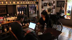 Orang-orang Lebanon duduk dengan laptop mereka di sebuah kafe di Beirut pada 14 Januari 2022. Kafe-kafe Beirut sekarang berfungsi sebagai tempat kerja pengganti bagi orang-orang yang bergulat dengan kekurangan listrik dan pemutusan internet yang berasal dari krisis ekonomi. (JOSEPH EID / AFP)