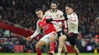 Pemain Arsenal, Leandro Trossard (kiri), dan pemain Liverpool, Florian Wirtz, saling berebut bola dalam pertandingan Liga Inggris di Emirates, Jumat (9/1/2026). (AP Photo/Ian Walton)