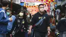 Pasangan memakai masker untuk mencegah penyebaran virus corona berjalan di pasar Dihua Street di Taipei, Taiwan, Rabu (10/2/2021).  Pasar Dihua Street di Taipei menjadi salah satu pasar terpopuler yang menjajakan perlengkapan Tahun Baru Imlek. (AP Photo/Chiang Ying-ying)