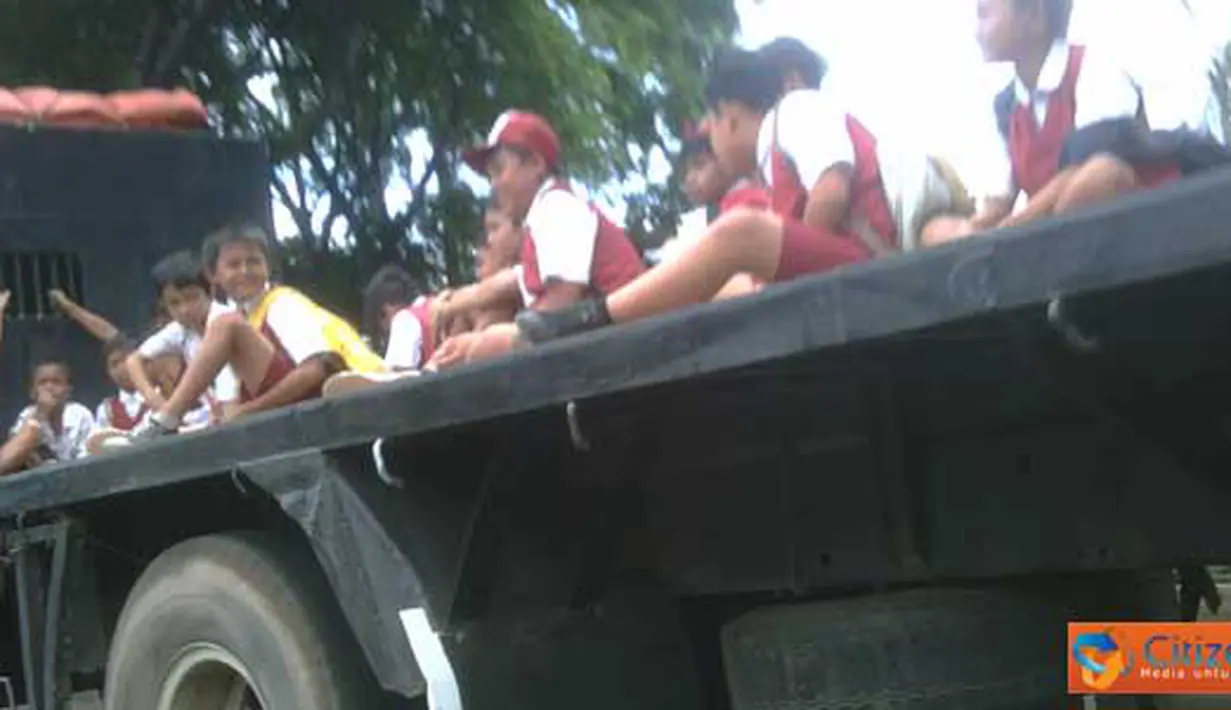 Anak-anak Sekolah Dasar (SD) naik mobil truk terbuka di Jalan Bekasi Timur, tepatnya depan penjara Cipinang. (Pengirim : Untung)
