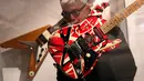 Seorang pria memeriksa gitar yang dibuat dan dimainkan oleh Eddie Van Halen selama pratinjau pers pameran Play It Loud: Instruments of Rock & Roll di Metropolitan Museum of Art di New York, 1 April 2019. Koleksi instrumen di pameran ini punya rentang usia dari 1939 hingga 2017. (AP/Seth Wenig)