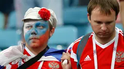 Suporter Rusia terlihat sedih setelah tim kesayangannya kalah dari Kroasia pada laga perempat final Piala Dunia 2018 di Stadion Olimpiade Fisht, Sabtu (7/7). Tuan rumah Rusia tumbang lewat adu penalti melawan Kroasia 3-4. (AP/Darko Bandic)
