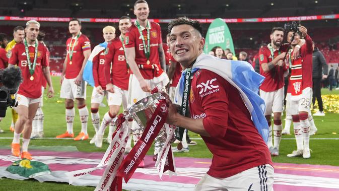 Bek Manchester United atau MU Lisandro Martinez merayakan trofi juara Carabao Cup 2022/2023 pada partai final di Stadion Wembley, Senin dini hari WIB (27/2/2023). Dua gol yang yang memupus catatan enam tahun MU puasa gelar setelah terakhir menjuarai Liga Europa 2016/2017 diciptakan Casemiro dan Marcus Rashford. (AP Photo/Alastair Grant)