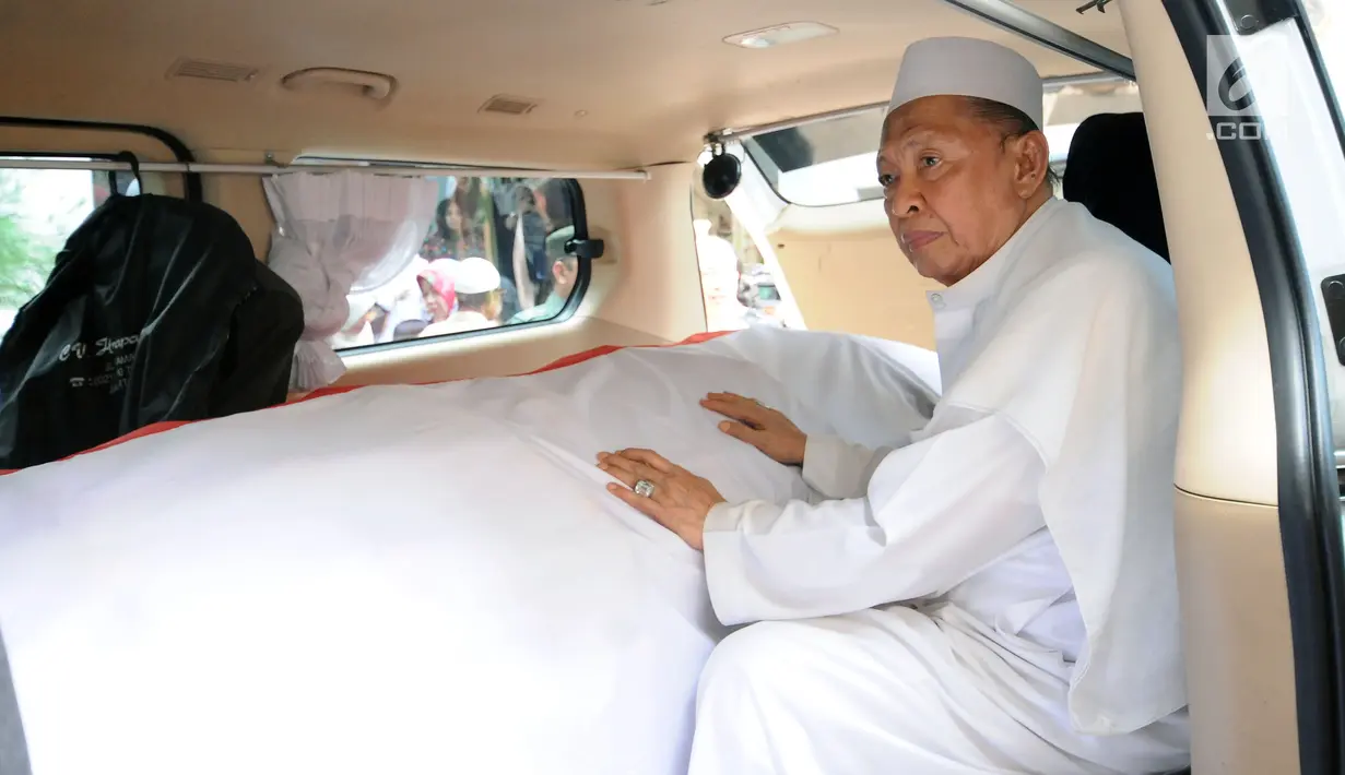 Wakil Presiden ke-9 RI, Hamzah Haz memegang peti jenazah istrinya, Asmaniah jelang diberangkatkan dari rumah duka di Jakarta, Selasa (12/9). Jenazah akan dimakamkan di pemakaman keluarga di Bogor, Jawa Barat. (Liputan6.com/Helmi Fithriansyah)